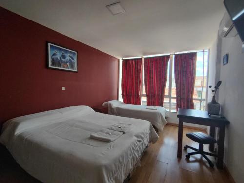 圣萨尔瓦多德朱Hotel Ery Noa的一间卧室设有两张床、一张桌子和一个窗口