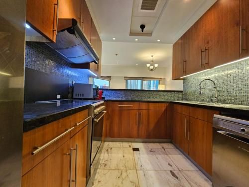 迪拜2 bedrooms flat in Central Park Tower, Dubai, DIFC的一个带木制橱柜和水槽的厨房