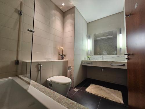 迪拜2 bedrooms flat in Central Park Tower, Dubai, DIFC的浴室配有卫生间、浴缸和水槽。