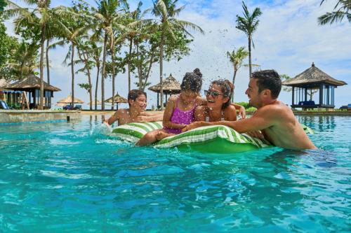 努沙杜瓦巴厘岛康拉德酒店的一群人坐在度假村的水里
