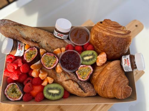 伊夫特河畔维勒邦Loft indépendant Proche Paris的托盘,包括不同种类的面包和水果