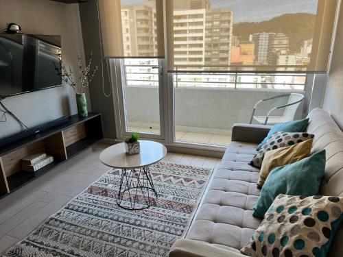 康塞普西翁Apartamentos Concepción Centro的客厅配有沙发和桌子