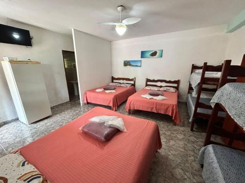 佩鲁伊比Pousada Geres Peruíbe的客房 - 带两张带橙色床单的床
