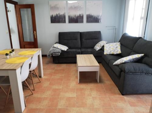 阿尔内迪略Apartamento las huellas的客厅配有沙发和桌子