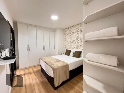 里约热内卢Excelente Apartamento no Leblon 02 quadras da praia em prédio com piscina, sauna e academia的一间小卧室,配有一张床和白色橱柜