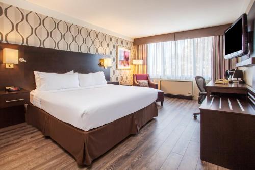 多伦多多伦多国际机场假日酒店的酒店客房设有一张大床和一台电视。