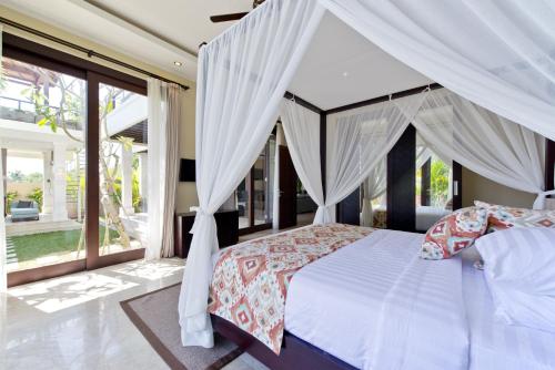 金巴兰Casa de Balangan Beach的一间卧室配有一张带天蓬的白色床