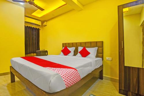 卡兰古特OYO Flagship Peppy Guest House的一间卧室配有一张带红色枕头的大床