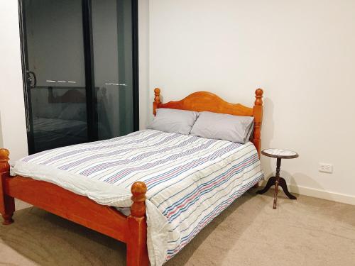 悉尼Parramatta 2B2B High Floor apt next to Train and shopping的卧室内的一张带木制床头板的床