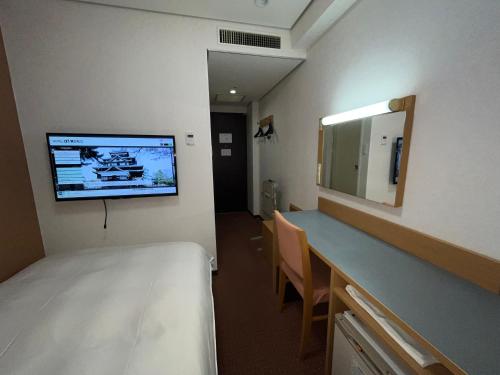 松江市Hotel Alpha-One Daini Matsue的一间医院间,配有床和镜子