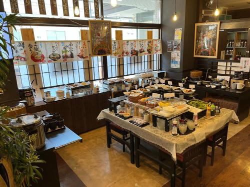 松江市Hotel Alpha-One Daini Matsue的一间餐厅,配有餐桌和食物