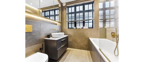 伦敦Luxury Abode: 5-Bed Haven Ideal for Big Groups!的一间带水槽、浴缸和卫生间的浴室