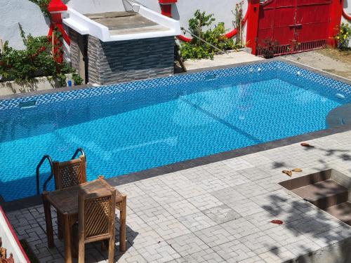 MalitbogPortofino Homestay的旁边设有1个带桌椅的大型游泳池