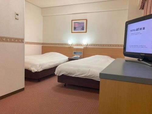 岩国市Hotel Alpha-One Iwakuni的酒店客房设有两张床和一台平面电视。
