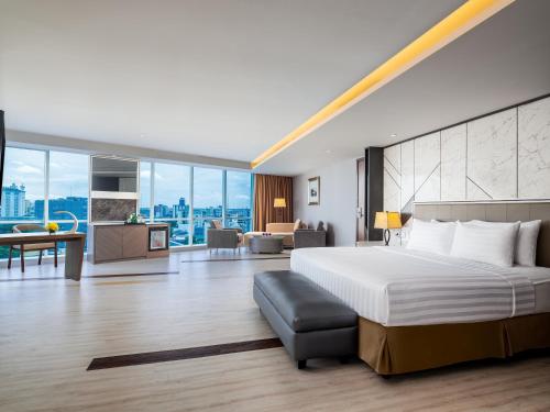 马卡萨ASTON Makassar Hotel & Convention Center的一间带大床的卧室和一间客厅