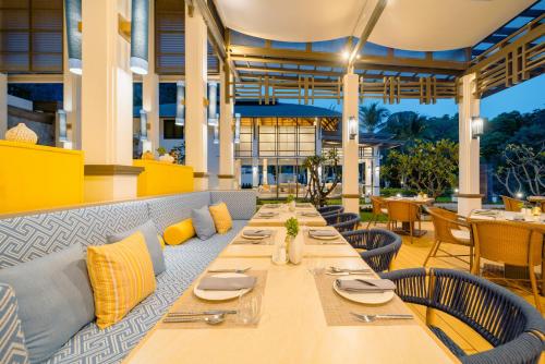 莱利海滩Bhu Nga Thani Resort & Villas Railay的一间带长桌和椅子的用餐室