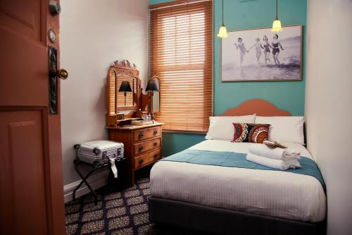 悉尼The Australian Heritage Hotel的卧室配有一张床,上面放着一只猫
