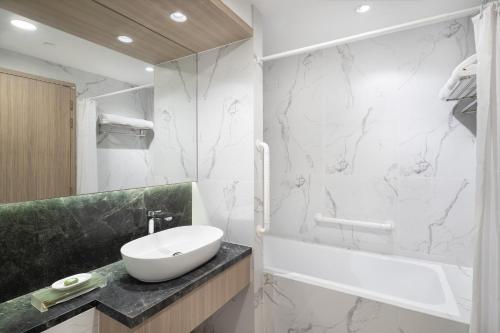 新加坡Park Avenue Clemenceau的一间带水槽、浴缸和卫生间的浴室