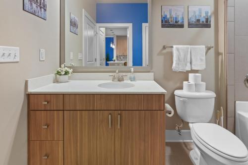 罗利City Living in Downtown Raleigh Luxury Apt 1的一间带水槽、卫生间和镜子的浴室