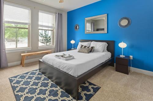 罗利City Living in Downtown Raleigh Luxury Apt 1的一间蓝色卧室,配有一张床和镜子