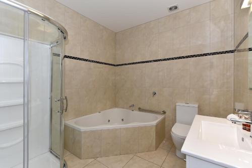 库克山村欧拉奇阁汽车旅馆的带浴缸、卫生间和盥洗盆的浴室