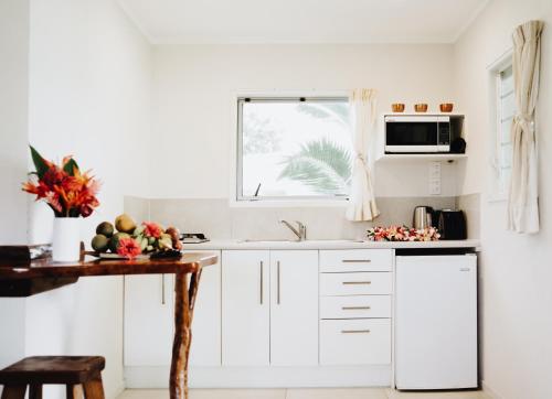 AmuriTai Marino - Beach Bungalows的厨房配有白色橱柜和窗户。