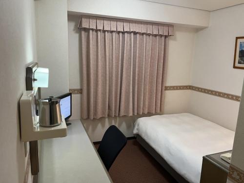 周南市Hotel Alpha-One Tokuyama的酒店客房配有一张床和一张带电脑的书桌
