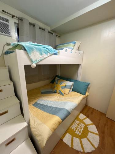 达沃市Micairan Suite的配有床单的小客房内的双层床