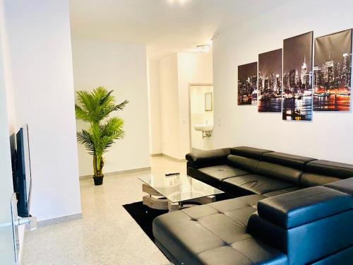 波恩Luxury Premium Apartments的客厅配有黑色真皮沙发和电视