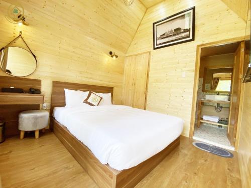 大叻Rung La Kim Resort的木制客房内的一间卧室,配有一张床