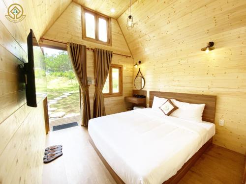 大叻Rung La Kim Resort的小木屋内一间卧室,配有一张床