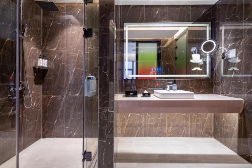 广州宜致酒店(广州番禺市桥地铁站店)的一间带水槽和镜子的浴室