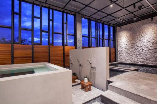 是拉差斯里拉卡海滨阳台服务公寓式酒店的带浴缸的浴室和大窗户