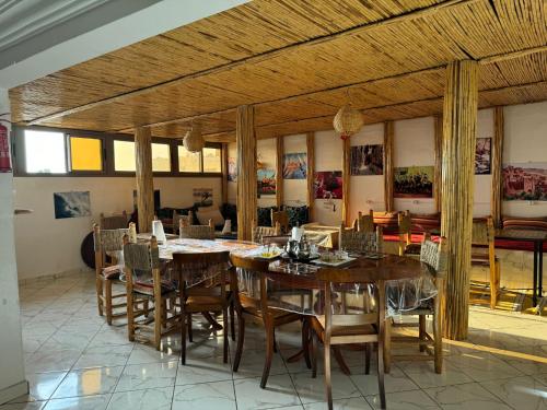 阿加迪尔Dinosaur Anza Surf House的用餐室配有木桌和椅子