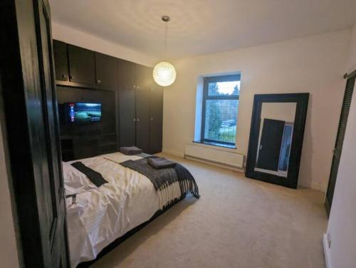 罗奇代尔2 BDR House - Ideal for Short Breaks & Contractors的一间大卧室,配有一张床和镜子