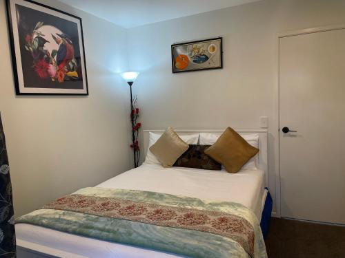 奥克兰Auckland CBD, Parnell Ensuite+Patio+Secluded Garage的卧室配有白色的床和枕头。