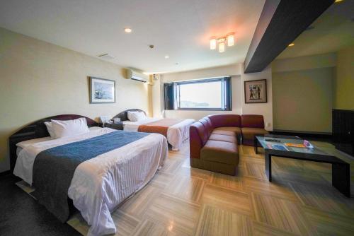 ホテル ラヴィアン HOTEL Lavien的酒店客房,设有两张床和一张沙发