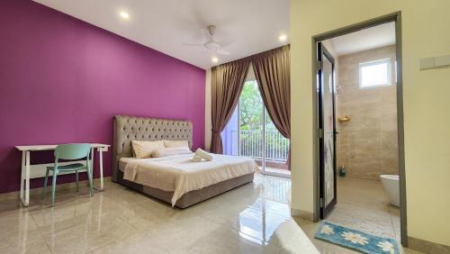 乔治市La Belle Maison 12 @ Gurney Kelawai/Pulau Tikus/Georgetown的卧室设有紫色墙壁、一张床和一张桌子