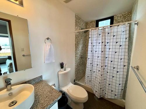 危地马拉Artistic Apartment in Zone 4的浴室配有卫生间、盥洗盆和淋浴。