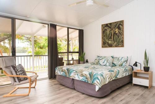 拉罗汤加穆里泻湖碧斯海滨度假屋的一间卧室配有一张床和一把椅子