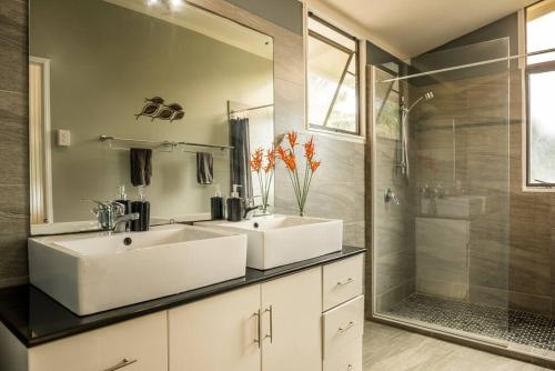 拉罗汤加穆里泻湖碧斯海滨度假屋的一间带两个盥洗盆和淋浴的浴室