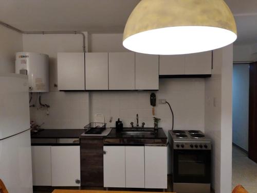 科尔多瓦Depa 900 cómodo remodelado centro cerca de todo的厨房配有白色橱柜、水槽和灯