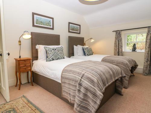 AlfordSouth Mains Cottage - Craigievar Castle的一间卧室设有两张床和窗户。