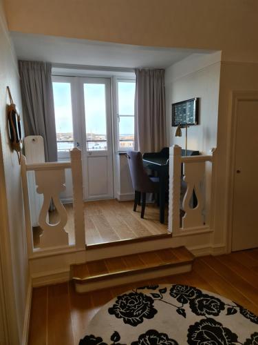 兰斯克鲁纳克洛南港口酒店的客厅配有桌子和带窗户的书桌