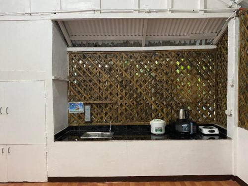 长滩岛Ati Lodge Boracay的厨房配有白色橱柜和带台面的墙壁