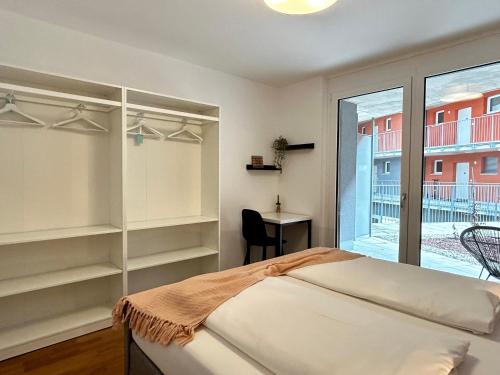 格拉茨sHome Apartments Graz - Self-Check-in & free parking的一间卧室配有一张床、一张书桌和一个窗户。