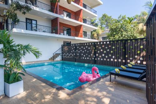 阿伯来Etereo Stays, Luxury Premium Apartments, Arpora, Goa的中间的游泳池,游泳池有粉红色的火烈鸟