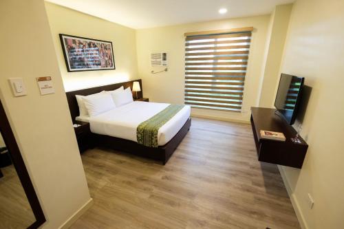 宿务Cebu Quincentennial Hotel的酒店客房,配有床和电视