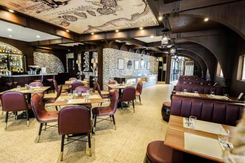 宿务Cebu Quincentennial Hotel的一间带木桌椅的餐厅和一间酒吧