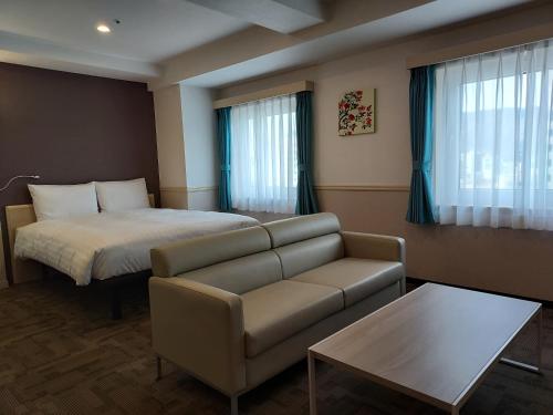 昌原市Toyoko Inn Changwon的酒店客房,配有床和沙发